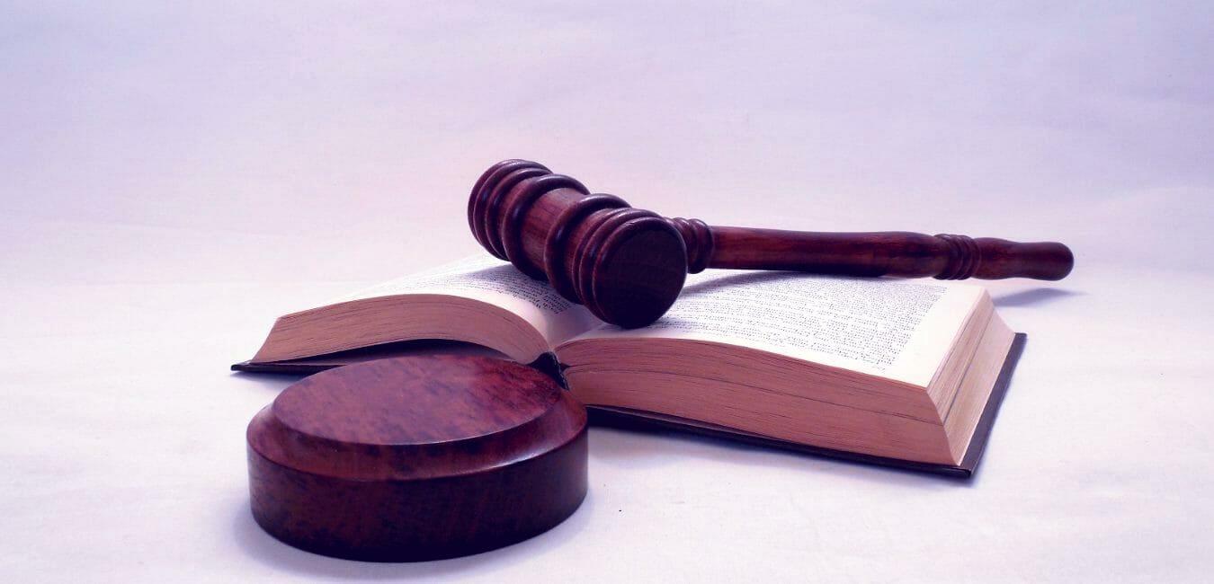 Image showing a court gavel, sounding block and a law book.